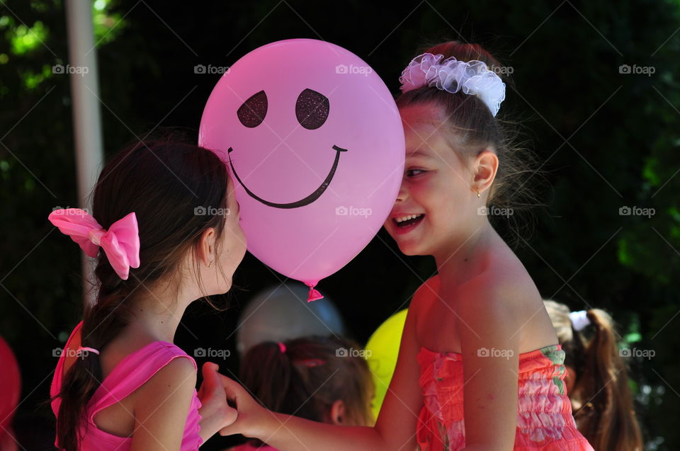Two  girls playing with ballon. Birthday party