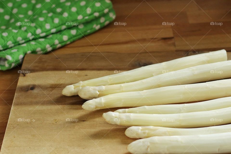 Close up of fresh raw asparagus on a wooden cutting board