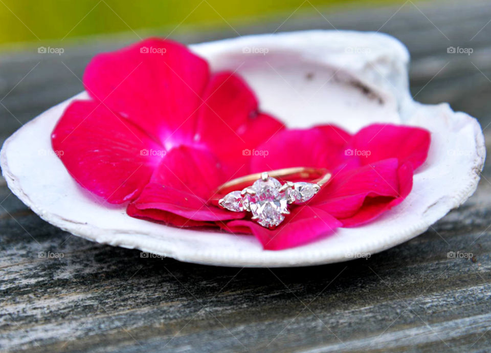 engagement ring. close up of diamond engagement ring with flowers and seashell