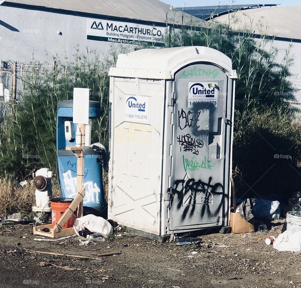 Port o potty,  that hasn’t been serviced in eons, out there by the city of Oakland and forgotten about BY the city of Oakland. In California.