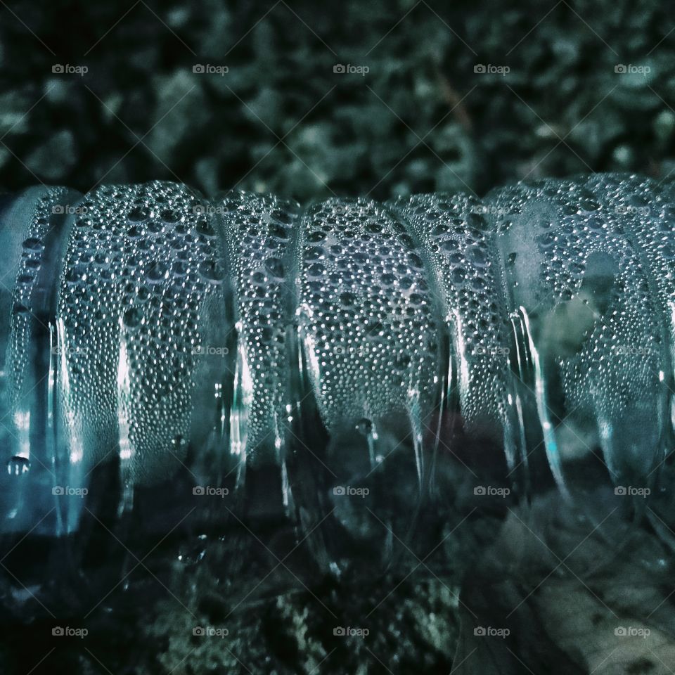 A bottle filled with mist inside by raining