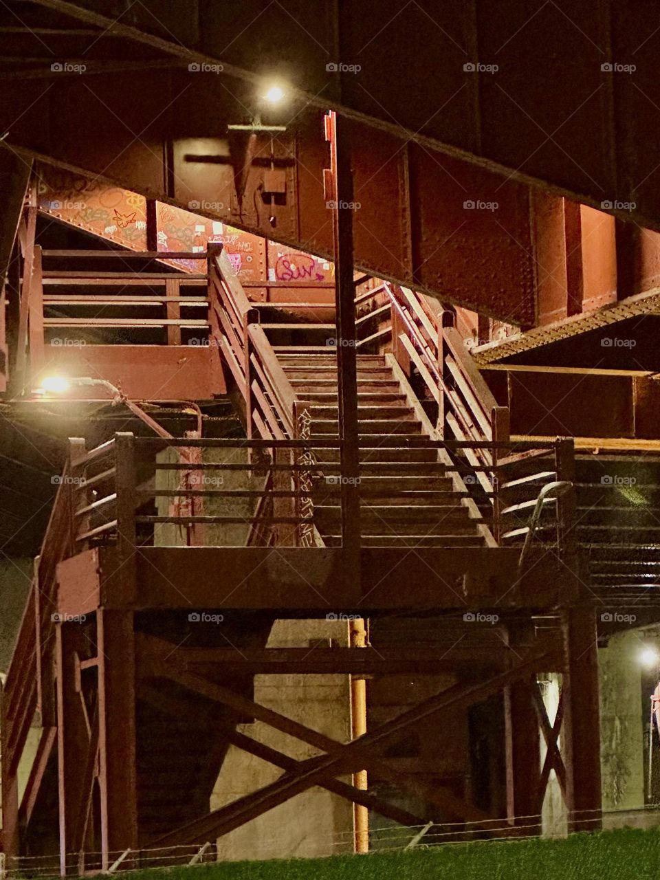This is the red metal staircase of the “Pulaski Bridge” at “Newtown Creek” on the “Greenpoint”, Bklyn side. After dark the stairs are illuminated which makes for a modern art motif worth photographing. 2023. Hypnotic Productions
