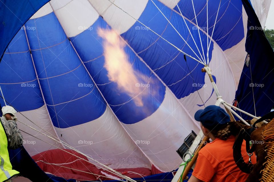 Young lady training to use the burner to inflate a hot air balloon at a Memorial Day festival in Fuquay Varina North Carolina in the Raleigh area. 