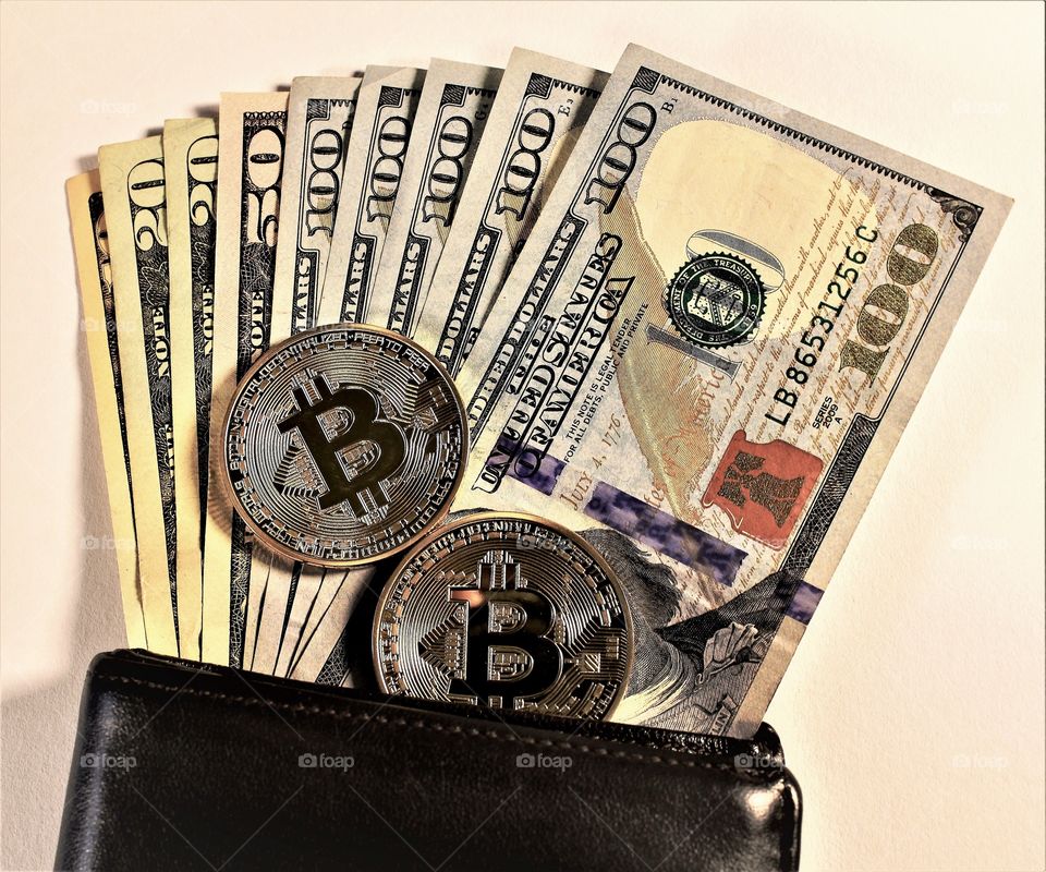 Bitcoin and cash spilling out of wallet 