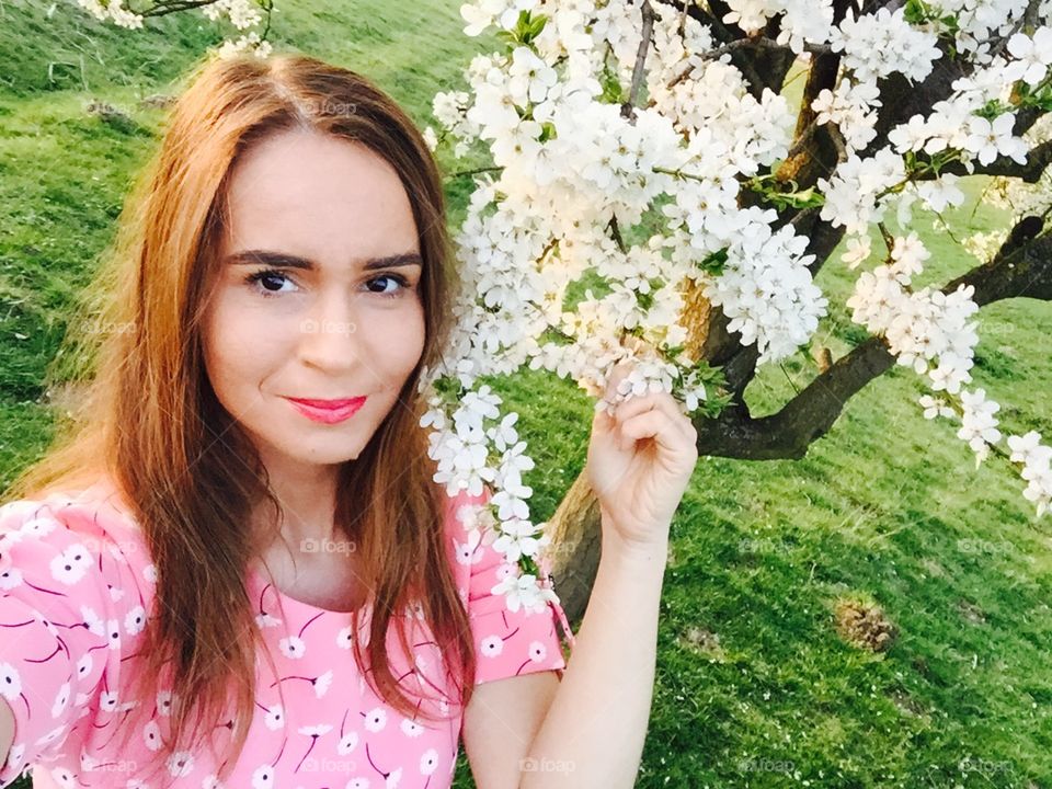 Spring portrait of woman surrounded by blooming trees