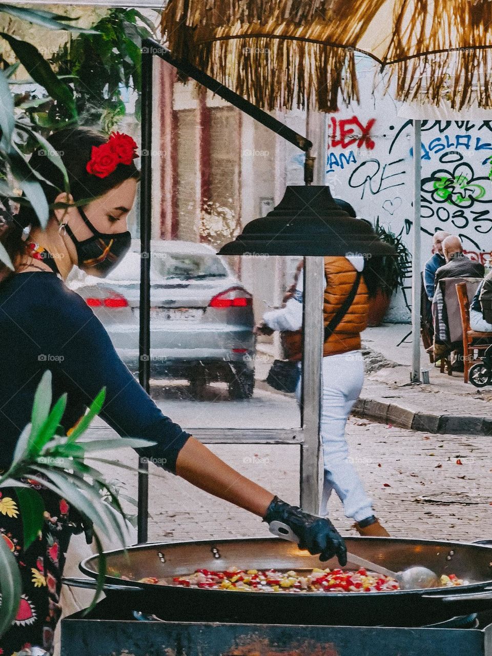 Woman cooking paella on the street during pandemic