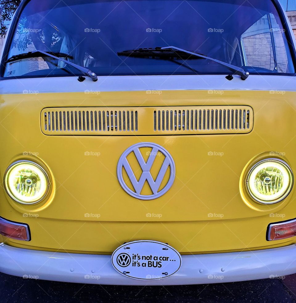 A Volkswagen Bus comes to life with green headlights giving it the appearance of a funny face