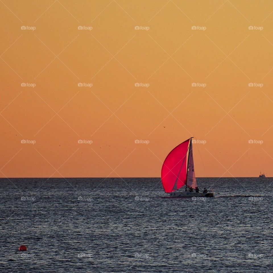 Red sail in sunset 