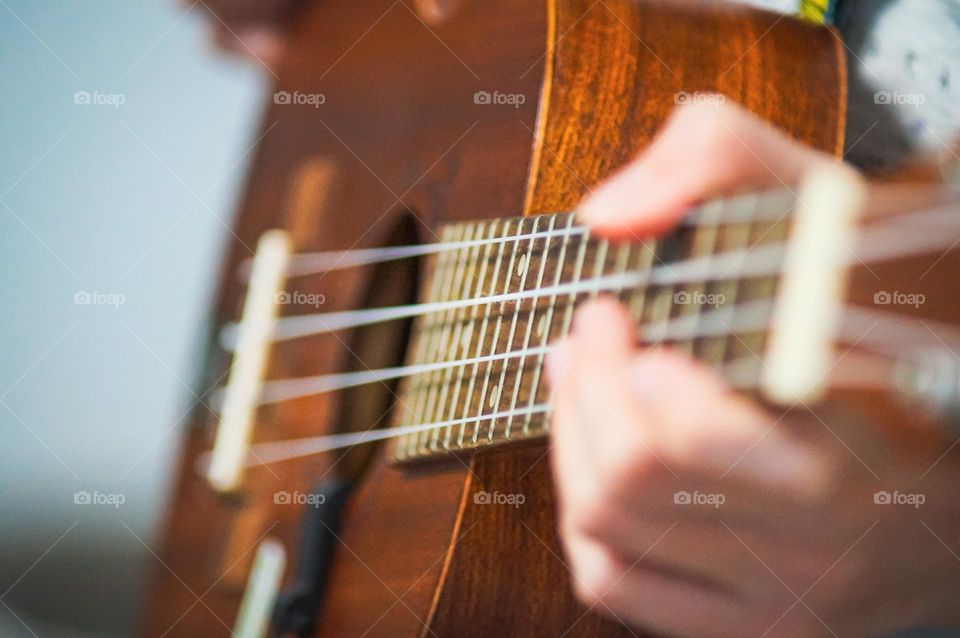 Young girl playing the ukulele