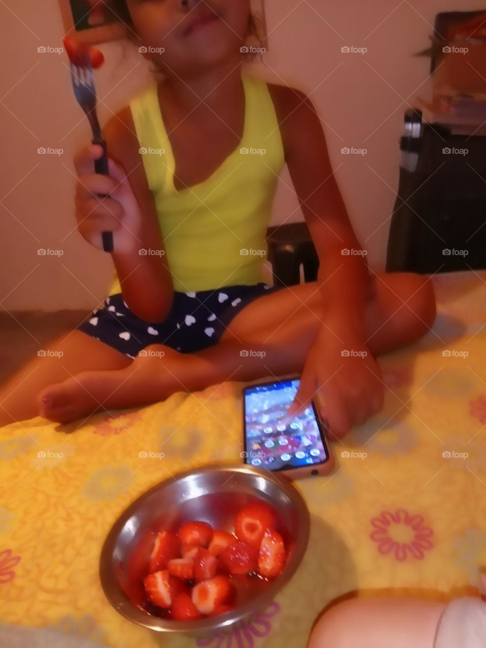 Editors'Choice Photo of the week Criança comendo uns deliciosos morando, com o celular ao lado