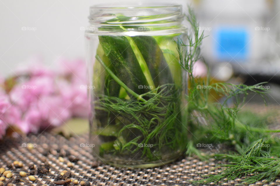 Close-up of pickle cucumber jar and herb