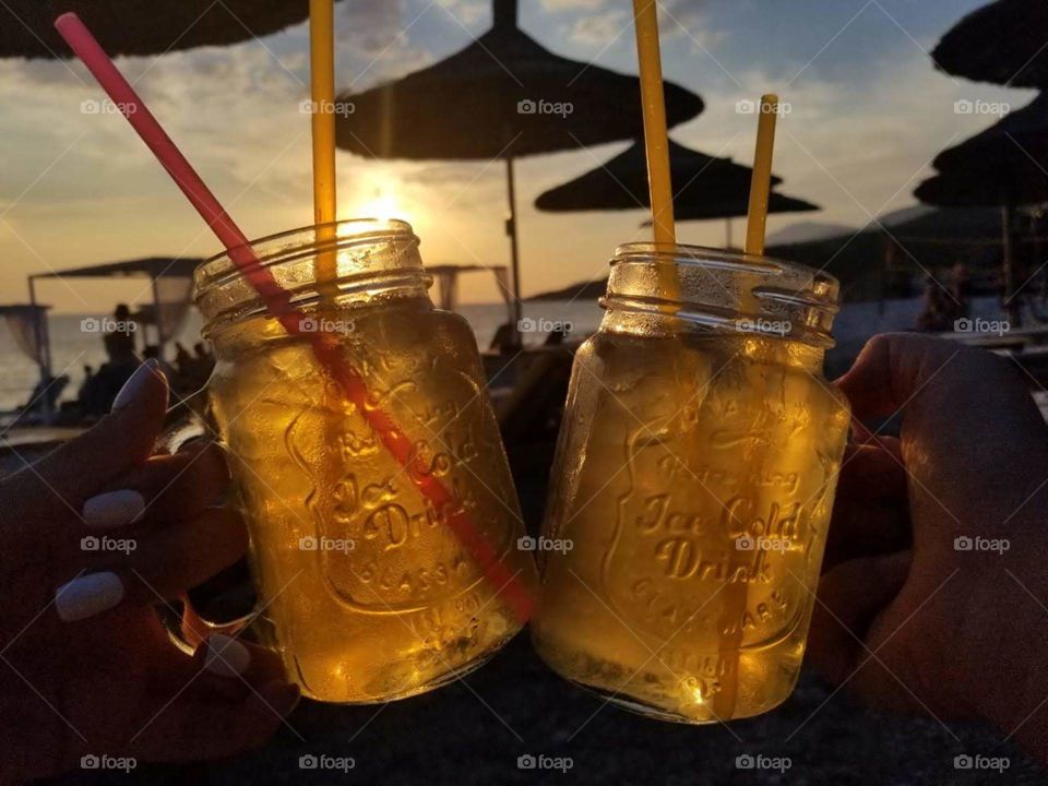 An ice cold drink, with a good friend, at the beach; perfect summer day.
