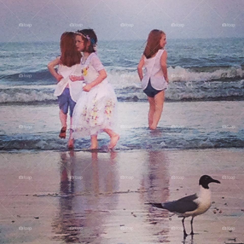 Girls playing in sea near bird