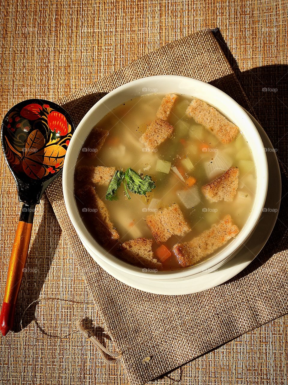 spoon with Khokhloma painting and a plate of soup