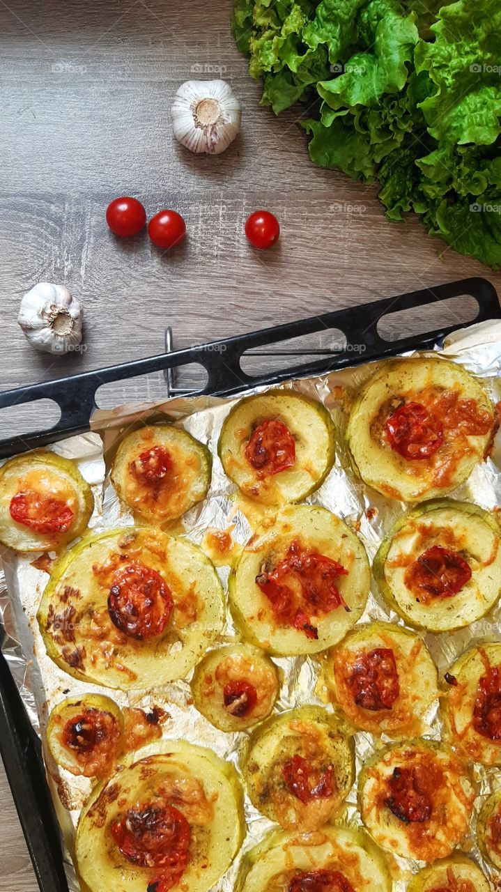 Baked zucchini with tomato and cheese in garlic