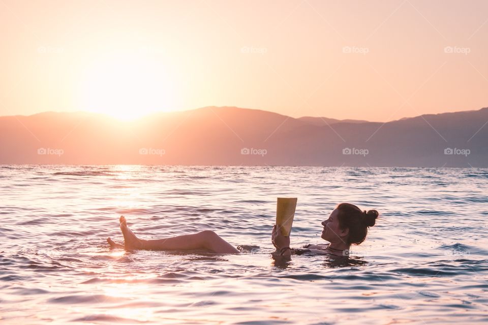 Relaxing and reading on the dead sea, Israel