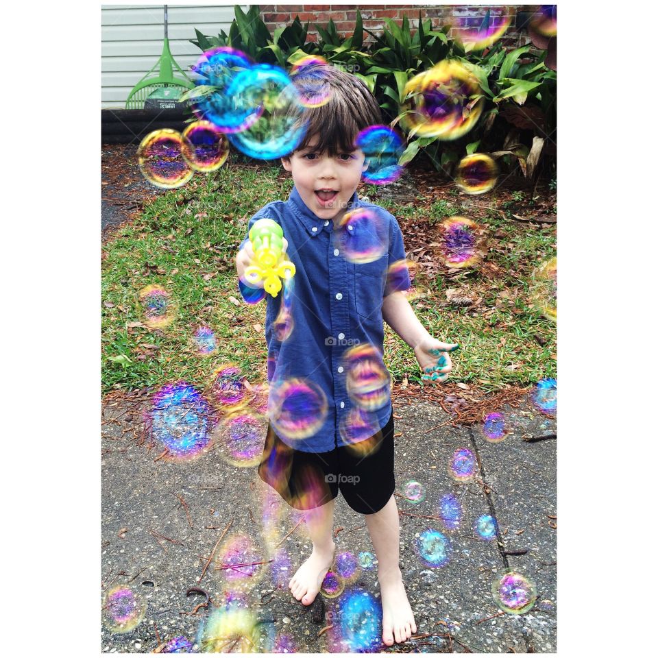 Boy shooting bubble from bubble gun in park