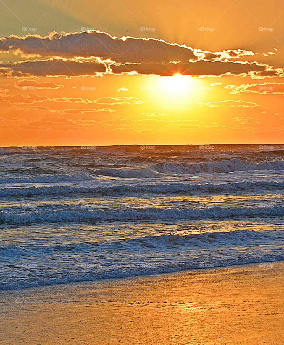  Spectacular sunset over the Gulf of Mexico - an unwavering gaze, as a fiery orange orb of light slowly sank beneath the horizon, and threads of light lingered in the sky, mingling with the clouds