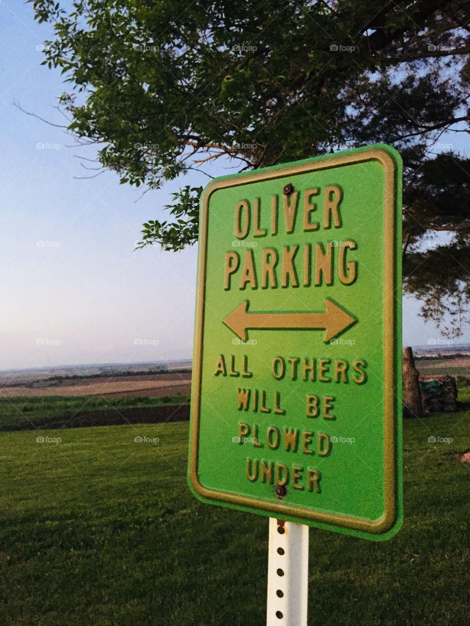 Oliver tractor priority-parking sign against a distant rural landscape 