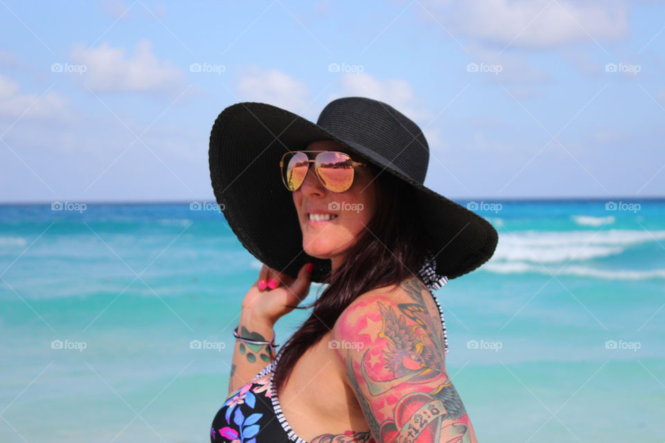 Smiling woman in sunglasses and swimwear at the Caribbean sea