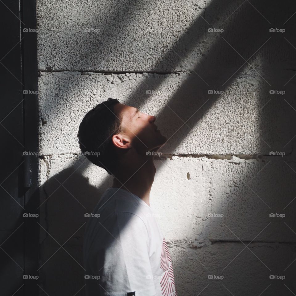 Young man standing under sunlight