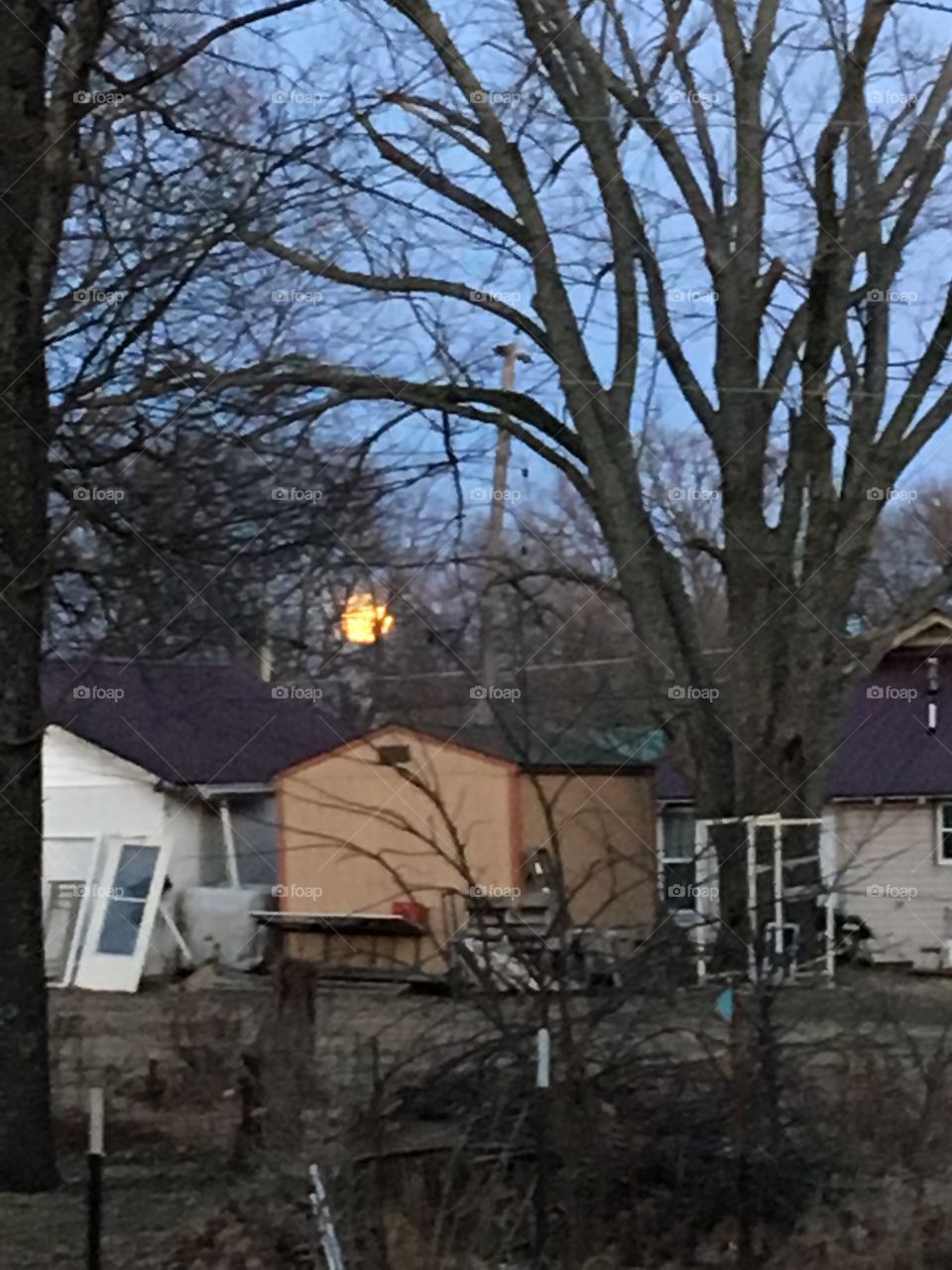 Just hanging above the rooftops the full moon is coming up quickly soon will be night.