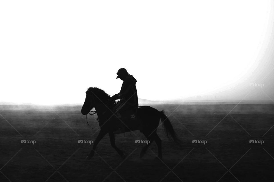 Man ride a horse in the dawn silhouette