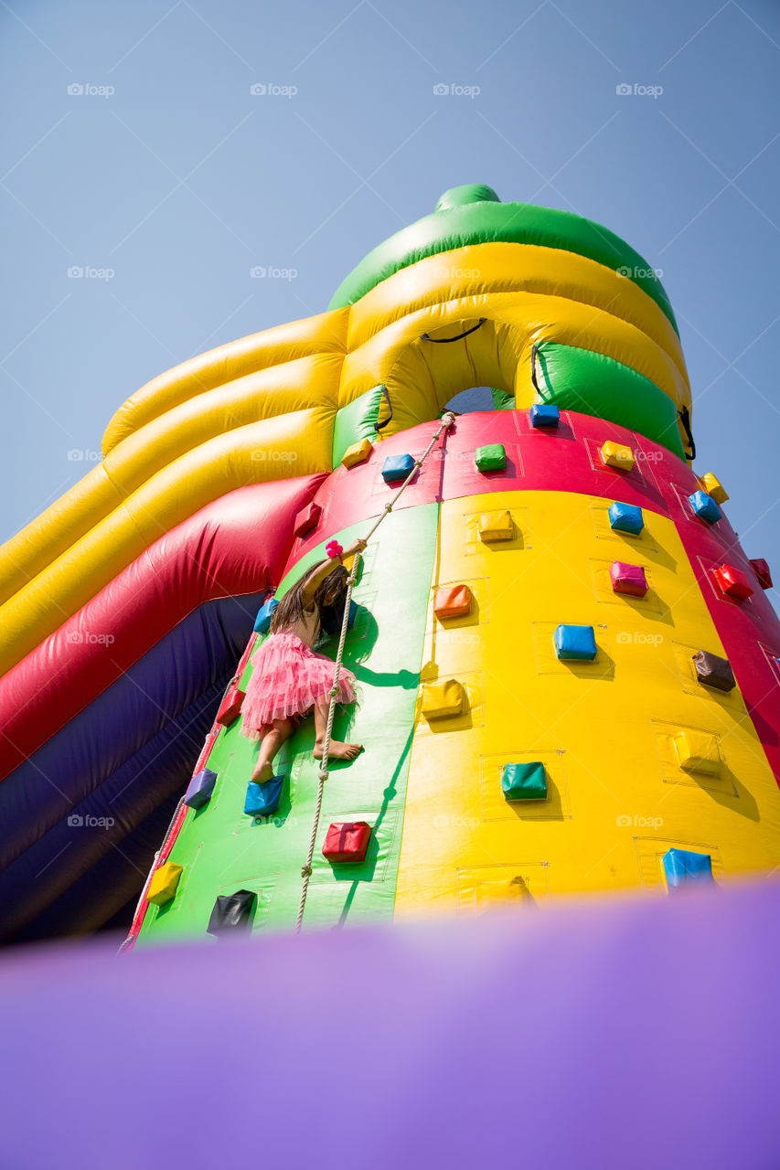 Summer memories - slides and obstacle courses. Image of girl climbing colorful obstacle course