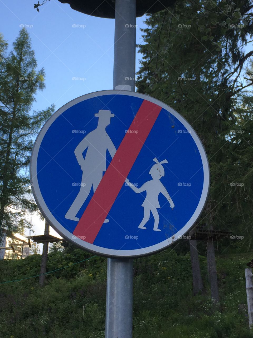 Strange sign against older man holding girls hands.