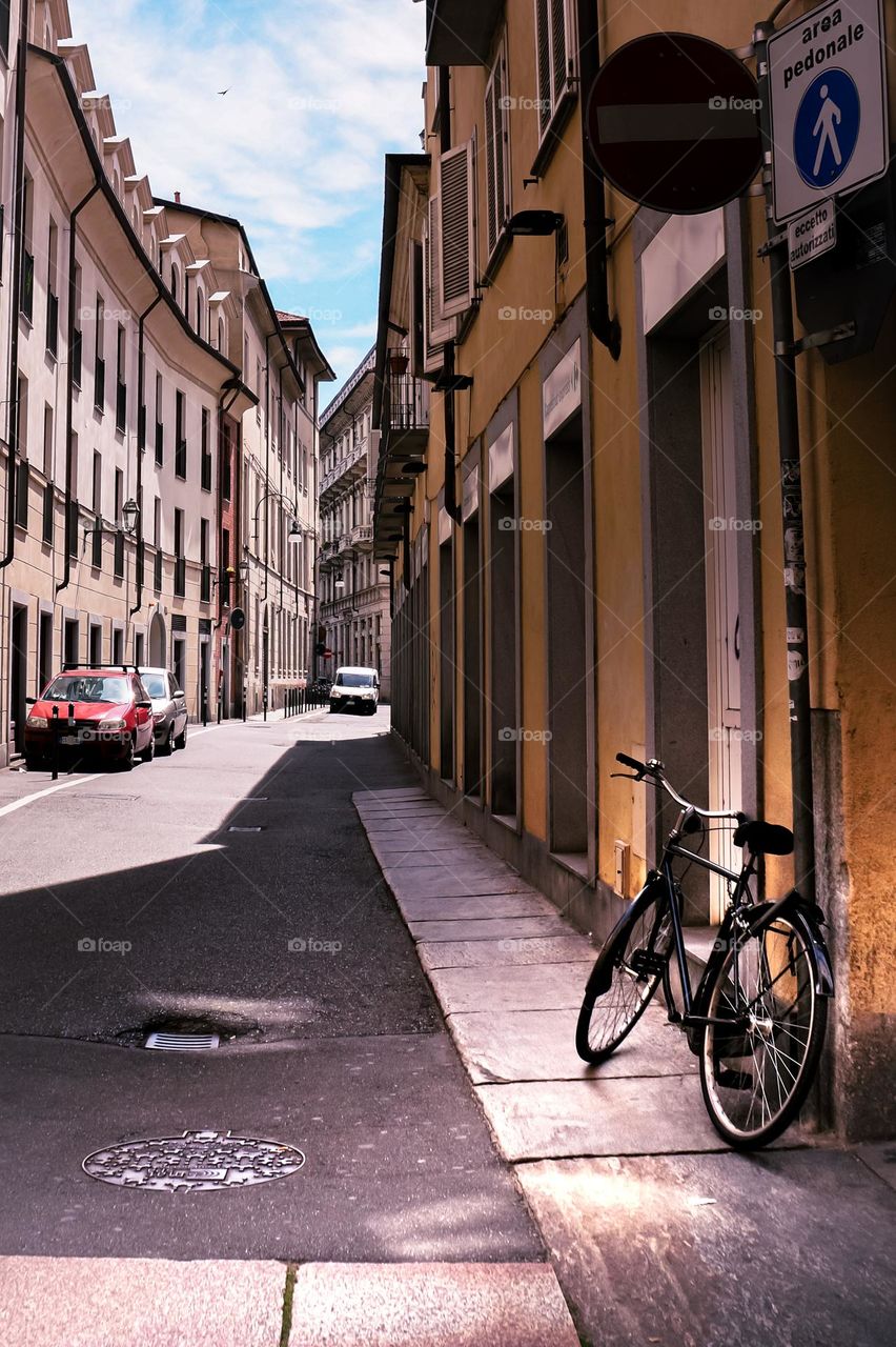 A bicycle is waiting for its rider on a street in Italy.
