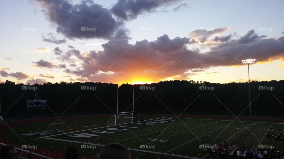 High School Graduation on the football field during sunset