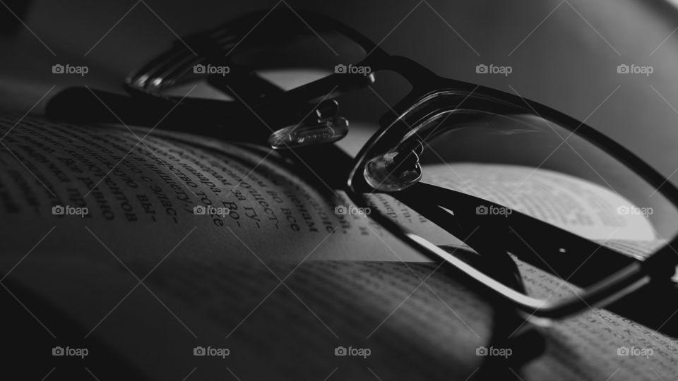 black and white photo.. glasses on the book