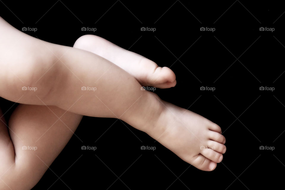 Babies foot against black background