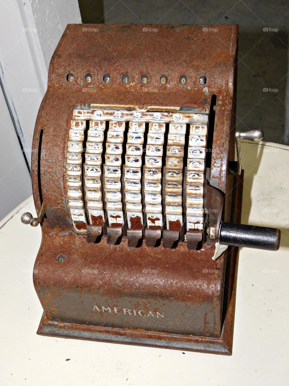 Vintage Vibes: a vintage "American" brand adding machine, specifically the Model 5. It is an early form of a mechanical calculator used for tasks like payroll distribution. 