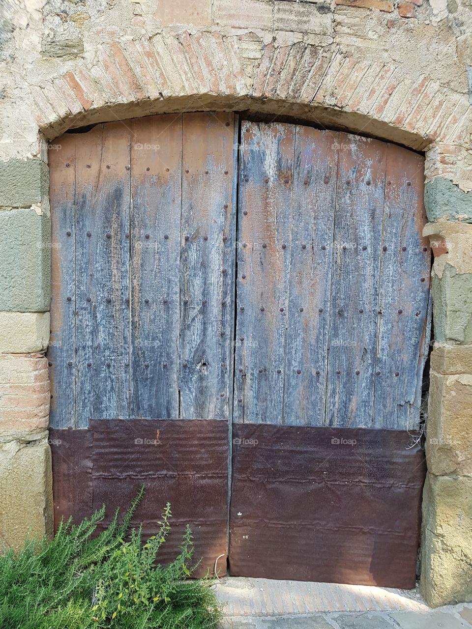 old wooden door with iron pieces at the bottom