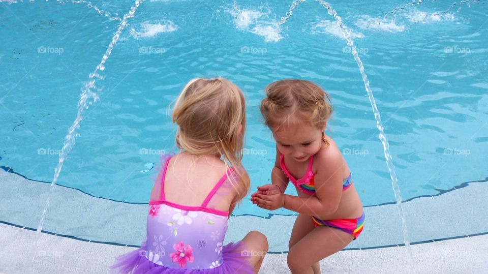 Cute sister near swimming pool