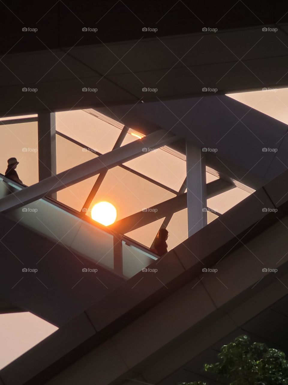 Sunset, people walking on the escalator