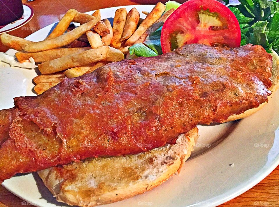 Fried Grouper sandwich with lettuce and tomato on sourdough bread with lettuce and tomato and French fries on the side! With tarter sauce on the side. 