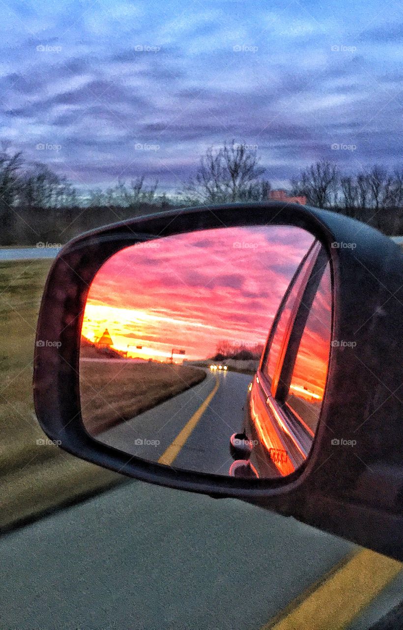 Dramatic sky reflected on side mirror