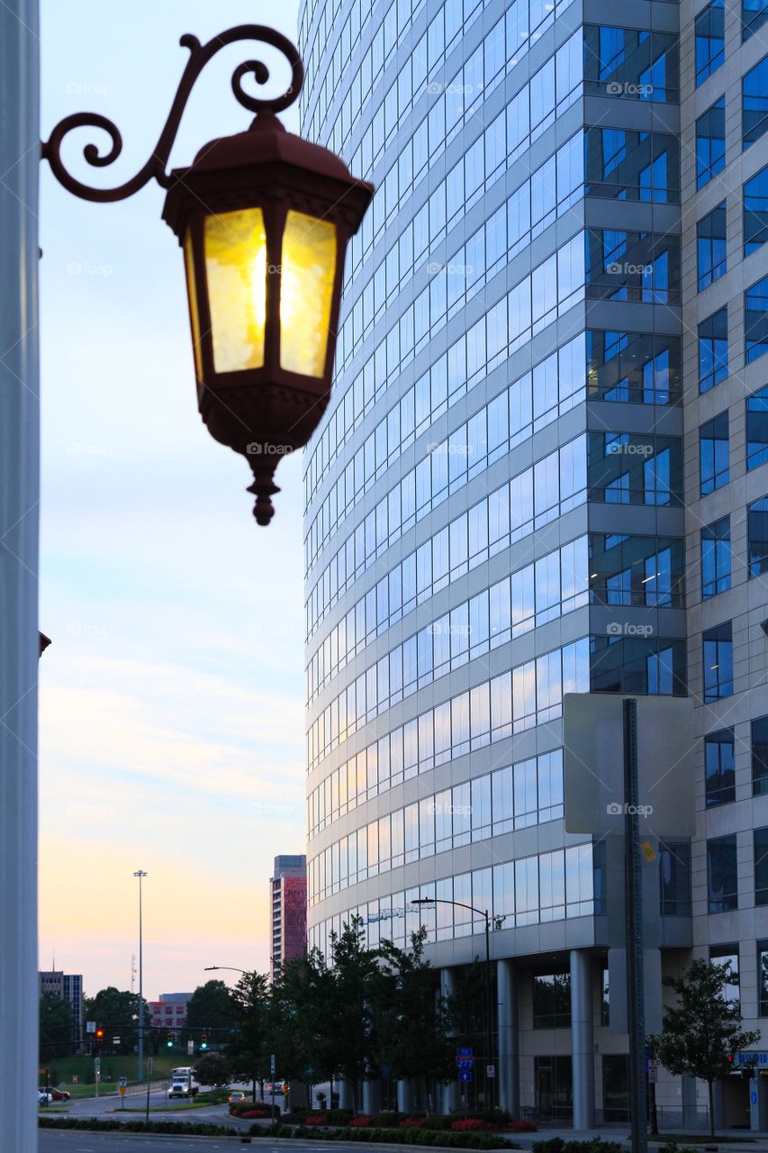 Street lamp in front of glass city building during sunset in charlotte North Carolina 