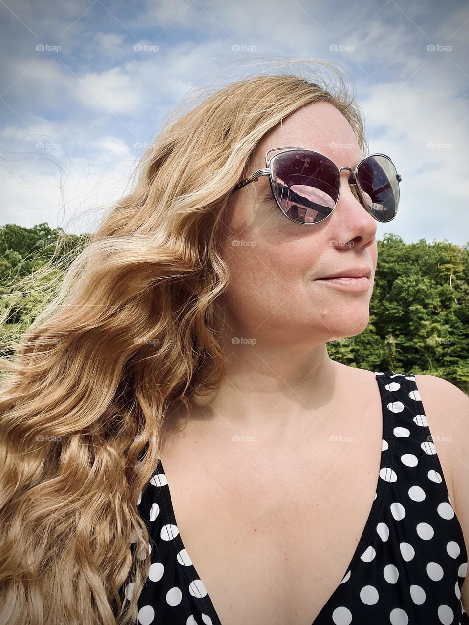 A woman with shiny wavy blonde wind blown hair