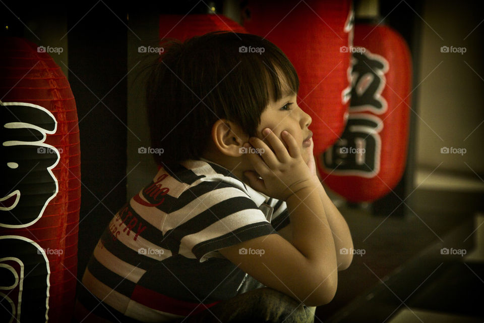 Young Asian boy sitting waiting. Thitiwin waiting for someone,something