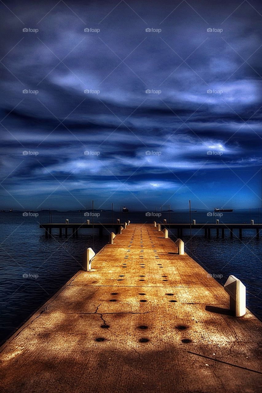 Pier against cloudy sky