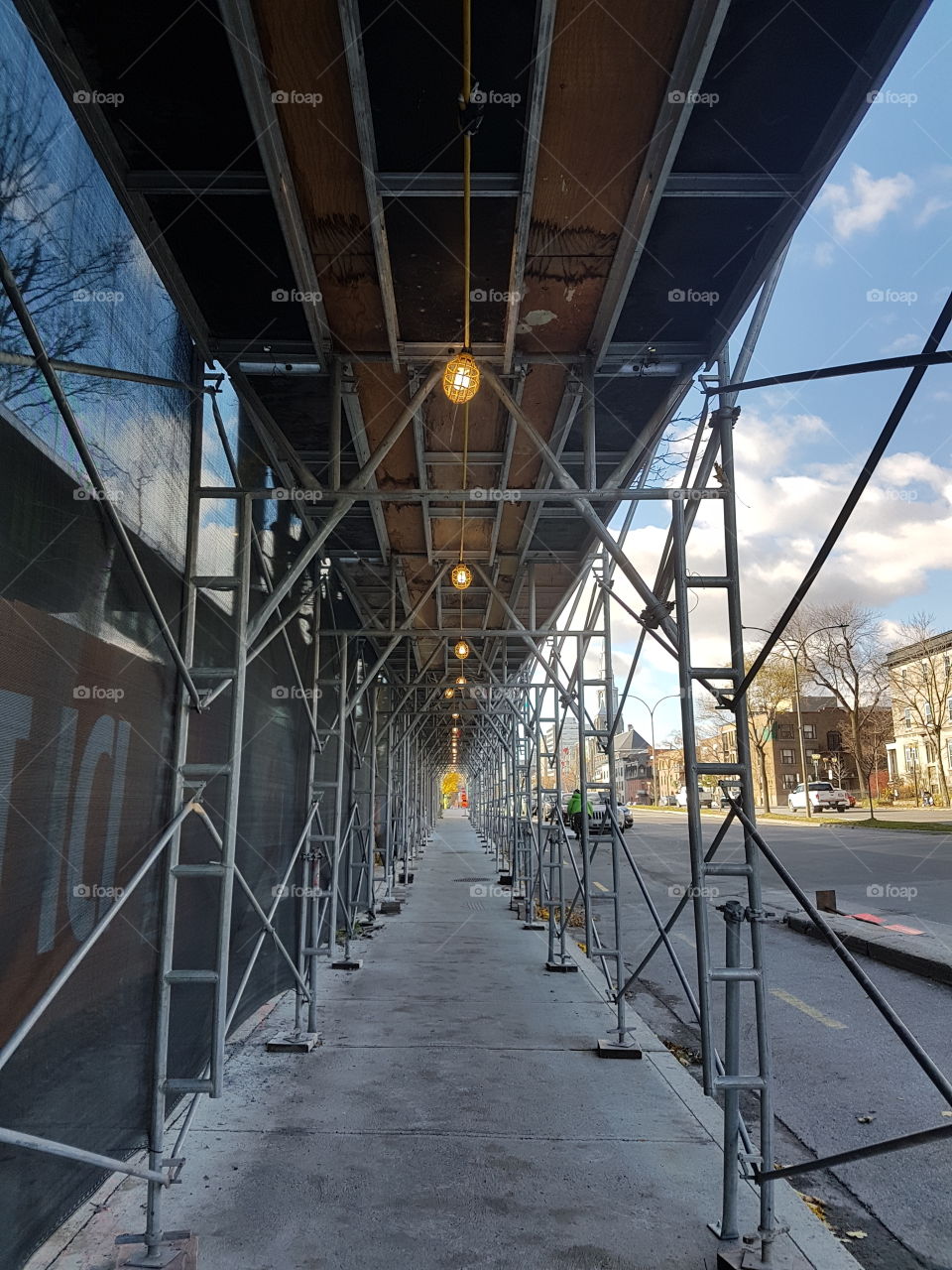 A long scaffolding covering the pavement like a tunnel. Montréal, Québec, Canada.