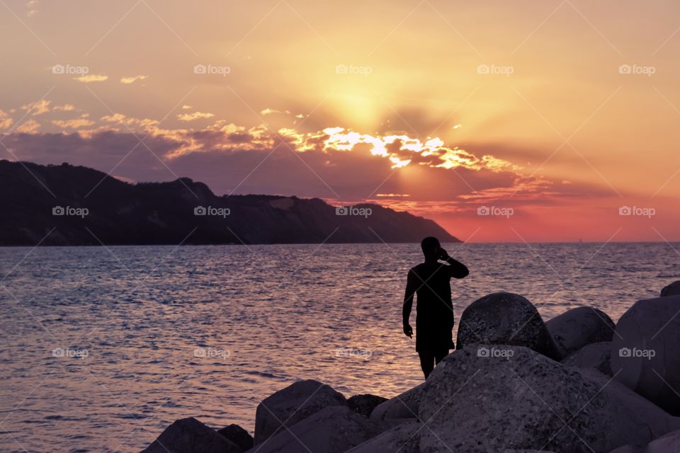 Silhouette of a man at sunset by the sea