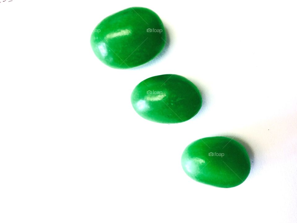 Green candies on white background