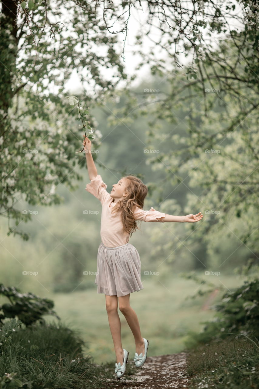 Girl in blossom garden at rainy day