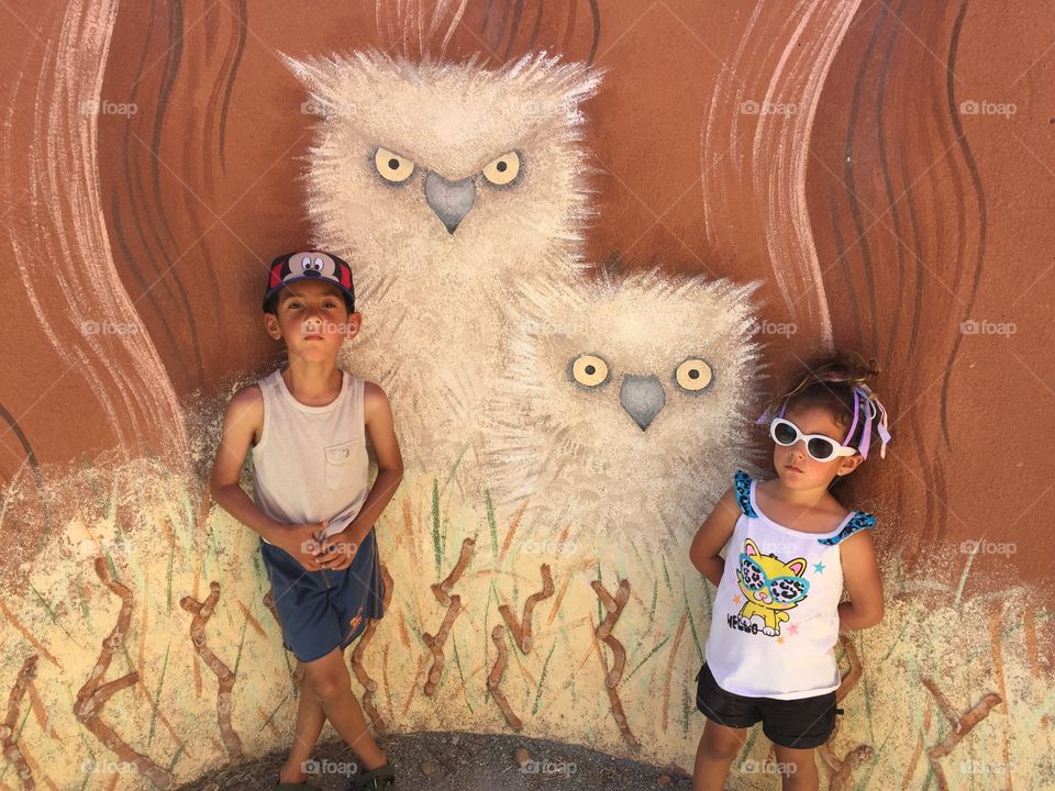Kids with owl painting inside tree