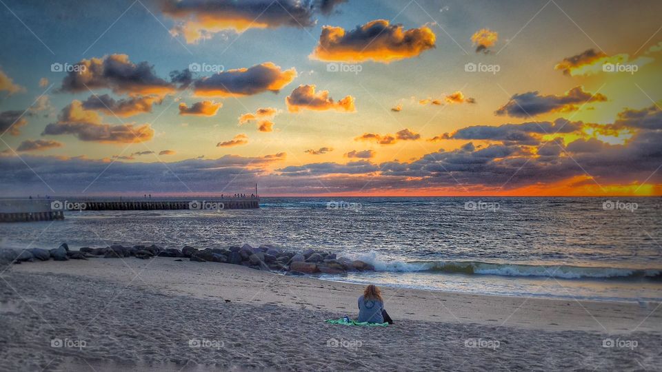 Rear view of woman sitting at beach