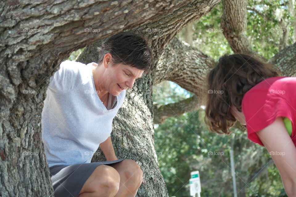 Mom and daughter climbing tree